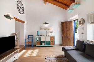 a living room with a couch and a clock on the wall at Quinta do Mestre - Casa Do Mar in Tavira
