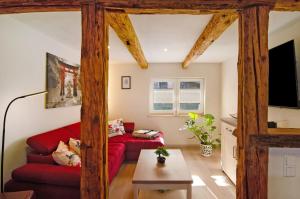 a living room with a red couch and a flat screen tv at Am Graben in Hasselfelde