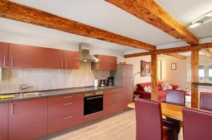 a kitchen with red cabinets and a dining room at Am Graben in Hasselfelde
