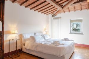 a bedroom with a white bed and a window at Borgo Syrah in Cortona +258 photos