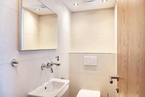 a bathroom with a sink and a mirror and a toilet at Apart Elena in See +19 photos