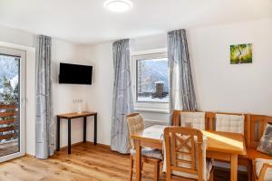 a dining room with a table and chairs and a window at Apart Elena in See