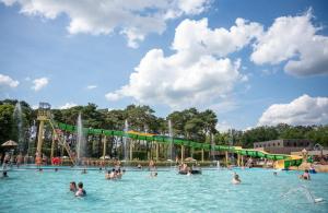 a large swimming pool with people in the water at Luxe chalet voor gezinnen in familiepark Goolderheide met openlucht zwembaden en ruim overdekt terras 24m2 in Bocholt