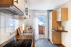 a kitchen with a sink and a large window at Apart Elena in See