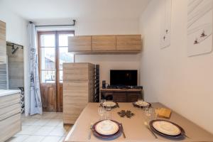 a kitchen with a table with plates and wine glasses at Les Narcisses in Morillon +13 photos