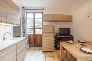 a kitchen with a sink and a table with a tablektop at Les Narcisses in Morillon