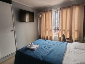 a bedroom with a blue bed with a towel on it at Hospedaje costa pacífico in Chimbote +2 photos