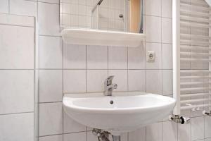 a bathroom with a white sink and a mirror at Haus Seeadler Wohnung 10 in Koserow +27 photos
