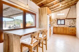 a kitchen with a table and chairs and a large window at Casa Stone in Benissa