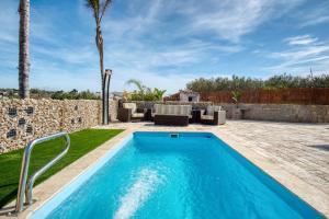 a swimming pool in a backyard with a patio furniture and palm trees at Casa Stone in Benissa
