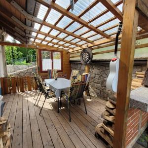 a patio with a table and chairs on a wooden deck at Ferienwohnung Härtel in Schramberg