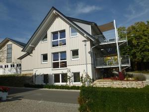 a large white house with a balcony at Apfelhof - Ferienwohnung Wielath in Salem