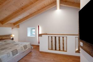 a bedroom with a bed and a wooden ceiling at Thari House Dolomiti in Piaia