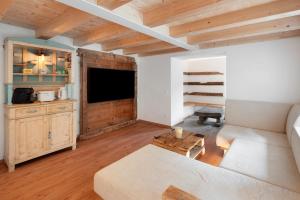 a living room with a couch and a tv at Thari House Dolomiti in Piaia