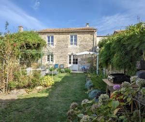 a stone house with a garden in front of it at Le Clos Pierreslogis in Theil-Rabier