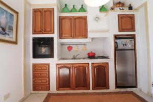 a kitchen with wooden cabinets and a refrigerator at Casa Kefera a Otranto in Otranto