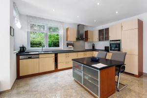 a kitchen with wooden cabinets and a black counter top at Ferienwohnung Milita in Lörrach +16 photos