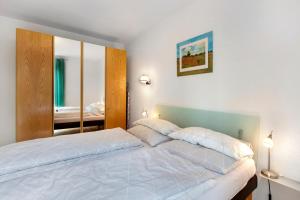 a bedroom with a large white bed with a mirror at Ferienwohnung Milita in Lörrach