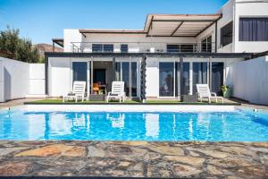 a house with a swimming pool in front of a house at Casa Amanecer 3 in Mácher +12 photos