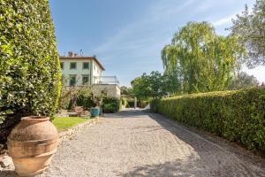 a walkway in front of a house with bushes at Borgo Syrah in Cortona