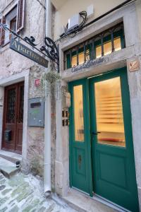 a building with green doors and a sign on it at Casa Libertà Suites & Studios Piran in Piran