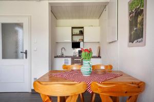 a dining room table with chairs and a vase of flowers at Appartement Braun 1 in Bolsterlang