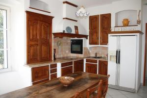 a kitchen with wooden cabinets and a wooden table at Le Mas des Cigales in Avignon