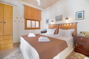 a bedroom with a large bed with two towels on it at The Sea Martin in Nydri