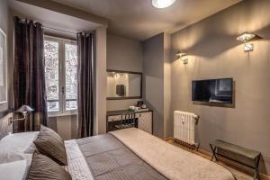 1 dormitorio con 1 cama, TV y ventana en Zero6 Guest House, en Roma
