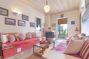 a living room with a red couch and a fireplace at The Sea Martin in Nydri