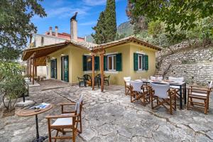 a patio with tables and chairs in front of a house at The Sea Martin in Nydri