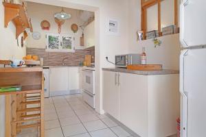 a kitchen with white cabinets and a refrigerator at The Sea Martin in Nydri
