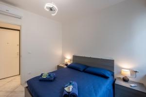 a bedroom with a blue bed with blue pillows at Casa Daniele Vista Mare - Sanremo in Sanremo
