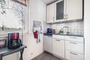 a kitchen with white cabinets and a coffee maker on a counter at Harmonie Tiny House in Oyten