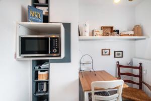 a kitchen with a table and a microwave on a wall at Harmonie Tiny House in Oyten