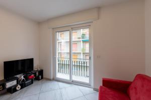 a living room with a red couch and a large window at Casa Daniele Vista Mare - Sanremo in Sanremo