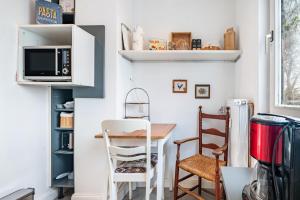 a small kitchen with a table and a microwave at Harmonie Tiny House in Oyten +14 photos