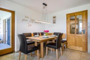 a dining room with a wooden table and black chairs at Ferienwohnung mit Bergblick in Edling