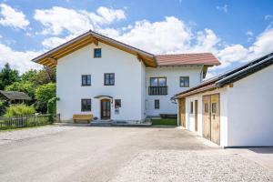 a large white house with a driveway at Ferienwohnung mit Bergblick in Edling