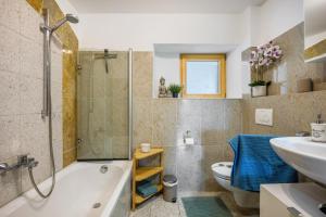 a bathroom with a tub and a toilet and a sink at Ferienwohnung mit Bergblick in Edling +23 photos