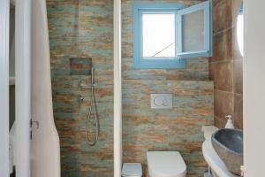 a bathroom with a shower and a toilet and a sink at Politimis Studio N4 in Amorgos