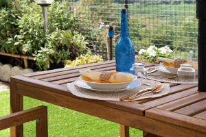 a wooden table with plates of bread and a blue bottle at La Casa di Giosy in Cairo Montenotte