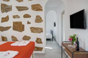 a bedroom with a wall decorated with rocks at Politimis Studio N4 in Amorgos
