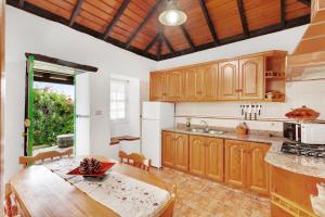 a large kitchen with wooden cabinets and a table at Casa Serradero in Tijarafe
