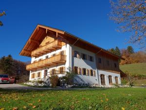 a large white building with a wooden roof at Exclusive 120 qm Wohnung am Wössner in Unterwössen