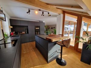 a kitchen with a black island and a wooden counter at Exclusive 120 qm Wohnung am Wössner in Unterwössen