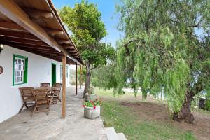 a patio with a table and chairs under a tree at Casa Serradero in Tijarafe