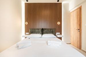 a bedroom with a white bed with a wooden headboard at Eldorado Luxury Villa in Afantou +29 photos
