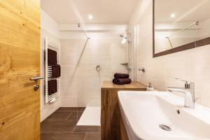 a bathroom with a sink and a mirror at Lechnerhof Wilde Kreuzspitze in Valles +20 photos