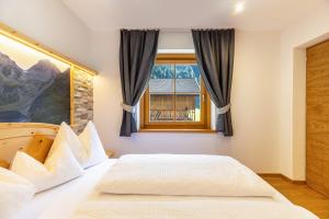 a bedroom with a bed and a window at Lechnerhof Wilde Kreuzspitze in Valles